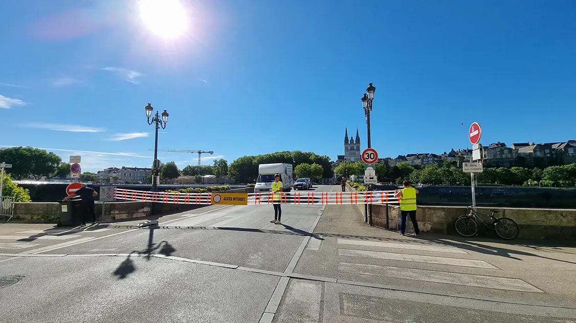 Barrière textile ACCÈS INTERDIT déployée en travers du pont de Verdun à Angers, cathédrale en arrière-plan
