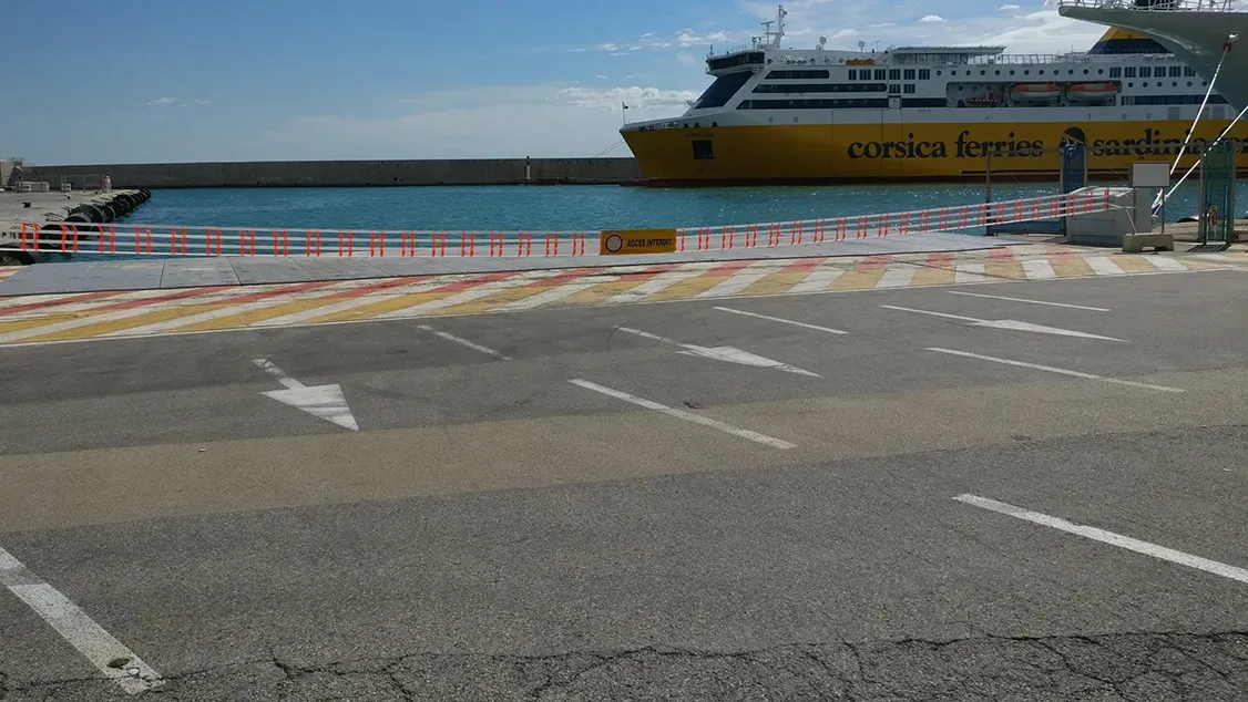 Barrière manuelle de 20 mètres fermant un quai du port de Nice, ferry en arrière-plan