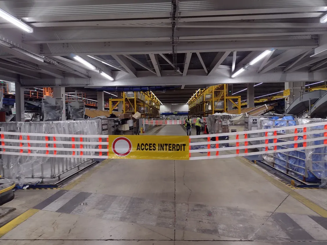 Barrière textile fermant une allée de site logistique